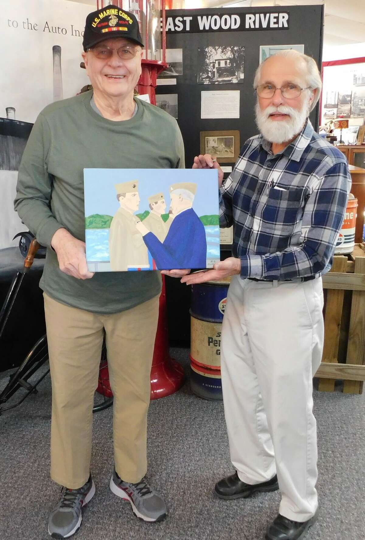 Michael Mossman, left, hand his painting of Joseph J. Barr to Robert LaMarsh, Director of the Wood River Museum and Visitors Center, where the painting can now be seen.
