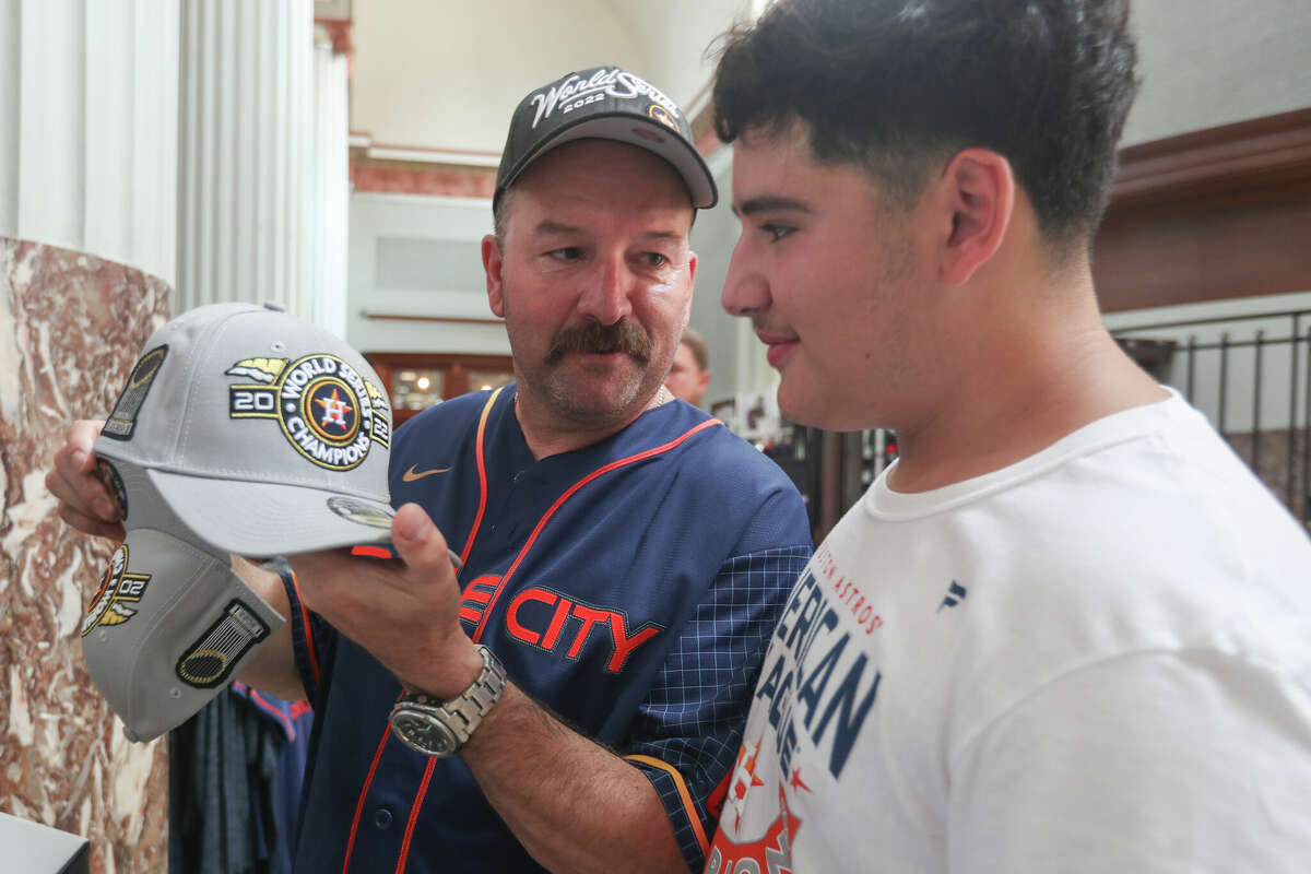 Rolandro Pruneda and his son, Rolando Jr. pick out World Series hat as fans flock to Minute Maid Park to purchase World Series apparel, Sunday, Nov. 6, 2022, in Houston.
