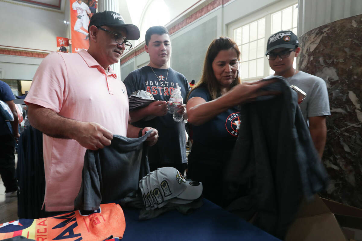 Leticia Barrios and her husband, Max, pick out shirts as fans flock to Minute Maid Park to purchase World Series apparel on Sunday, Nov. 6, 2022, in Houston.