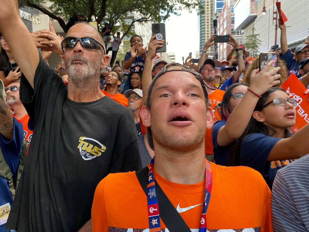 Alex Dehn, in orange shirt, had a job cleaning Minute Maid after games. He cheers with David Vicks at the Astros championship parade Nov. 7, 2022.