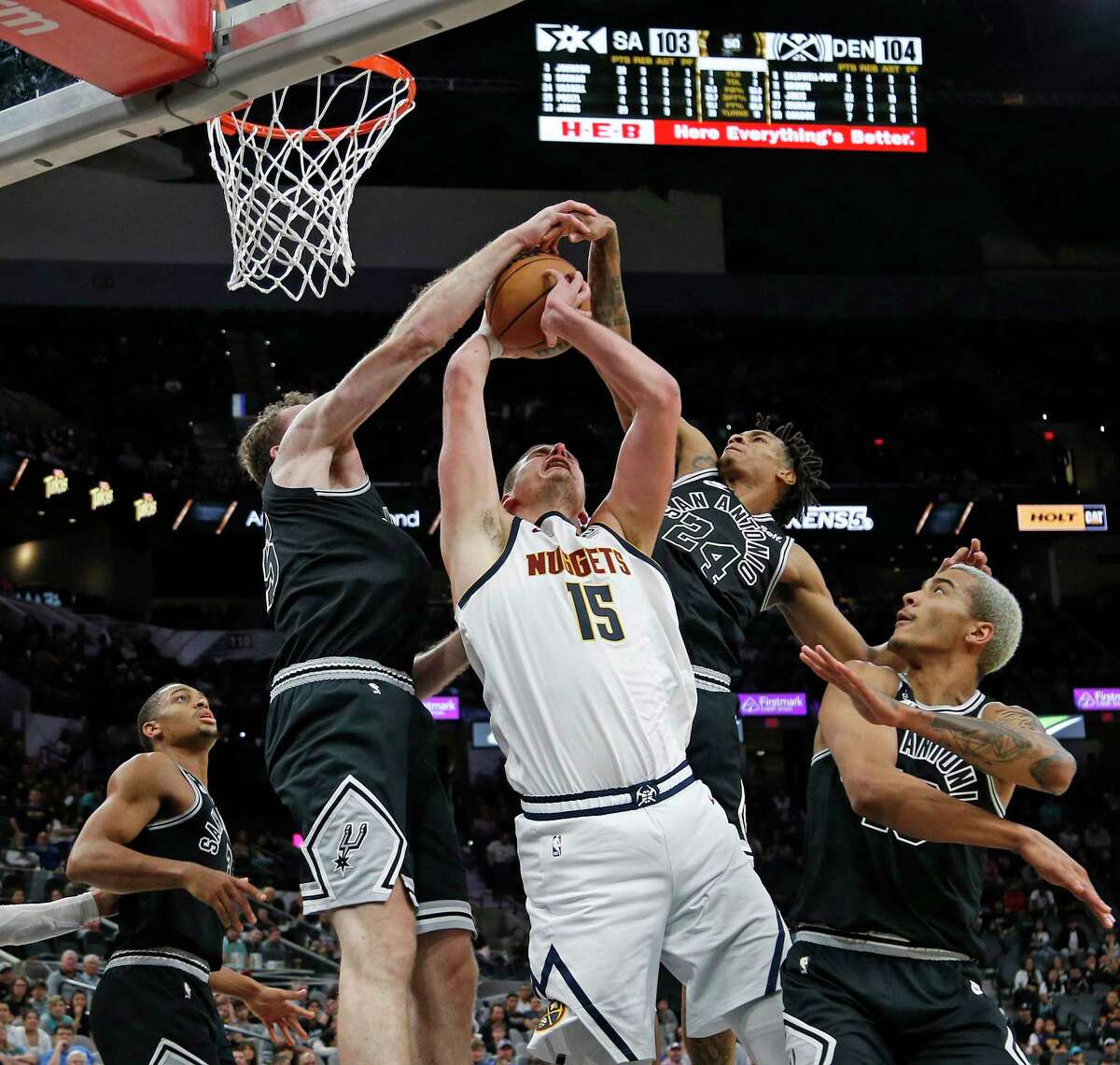 San Antonio Spurs Jakob Poeltl (25) combines with Devin Vassell (24) to tie up Denver Nuggets Nikola Jokic (15) in the second half on Monday, Nov. 7, 2022 at AT&T Center. Denver Nuggets defeated San Antonio Spurs 115-109.
