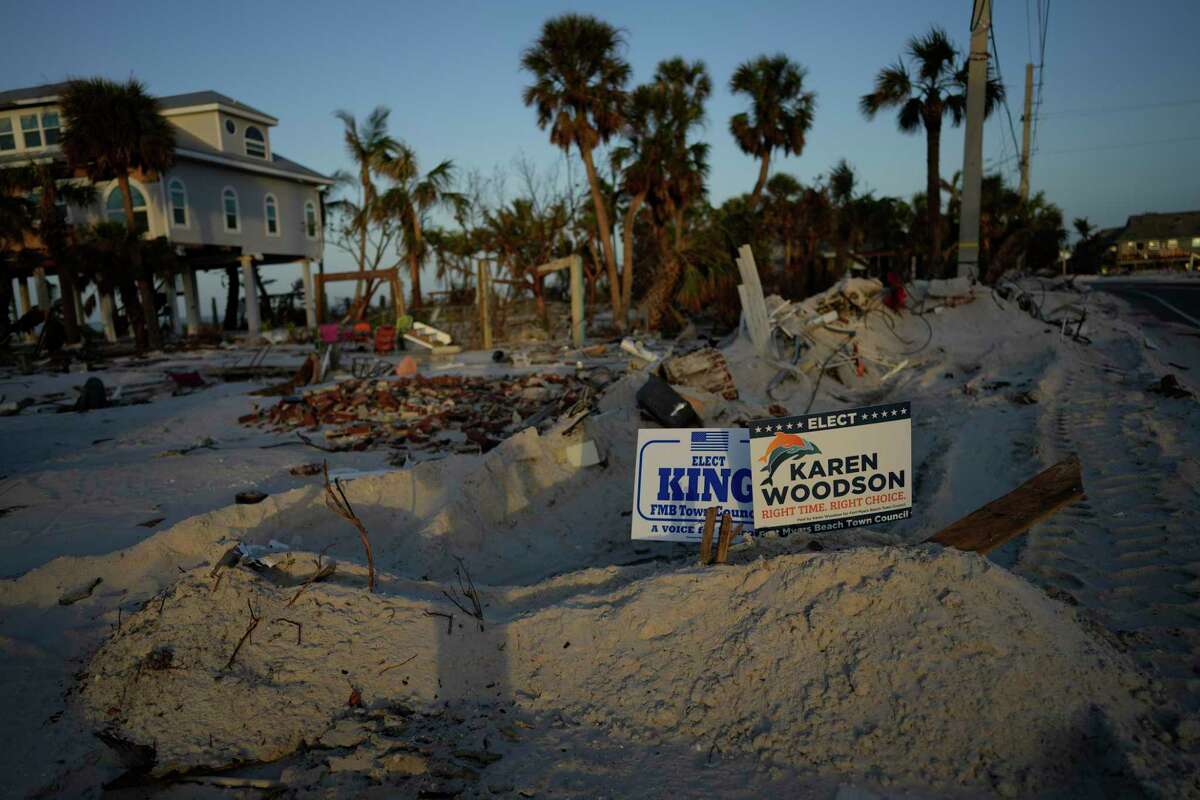 Signs promoting candidates for Fort Myers Beach town council sit along a roadside on Estero Island, which was heavily damaged in September's Hurricane Ian, in Fort Myers Beach, Fla, Tuesday, Nov. 8, 2022. After the area was devastated and thousands were left displaced by Hurricane Ian, Lee County extended their early voting period and permitted voters on Election Day to cast their ballot in any of the dozen open polling places.