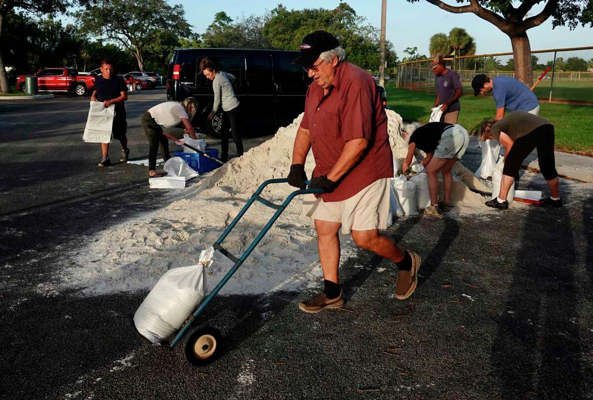 Sandbags are distributed at Mills Pond Park in Fort Lauderdale on Tuesday, Nov. 8, 2022 ahead of subtropical storm Nicole. Bags will be limited to six per car, proof of residency is required, bring your own shovel, while supplies last from 7am to 7pm. (Joe Cavaretta/South Florida Sun-Sentinel via AP)