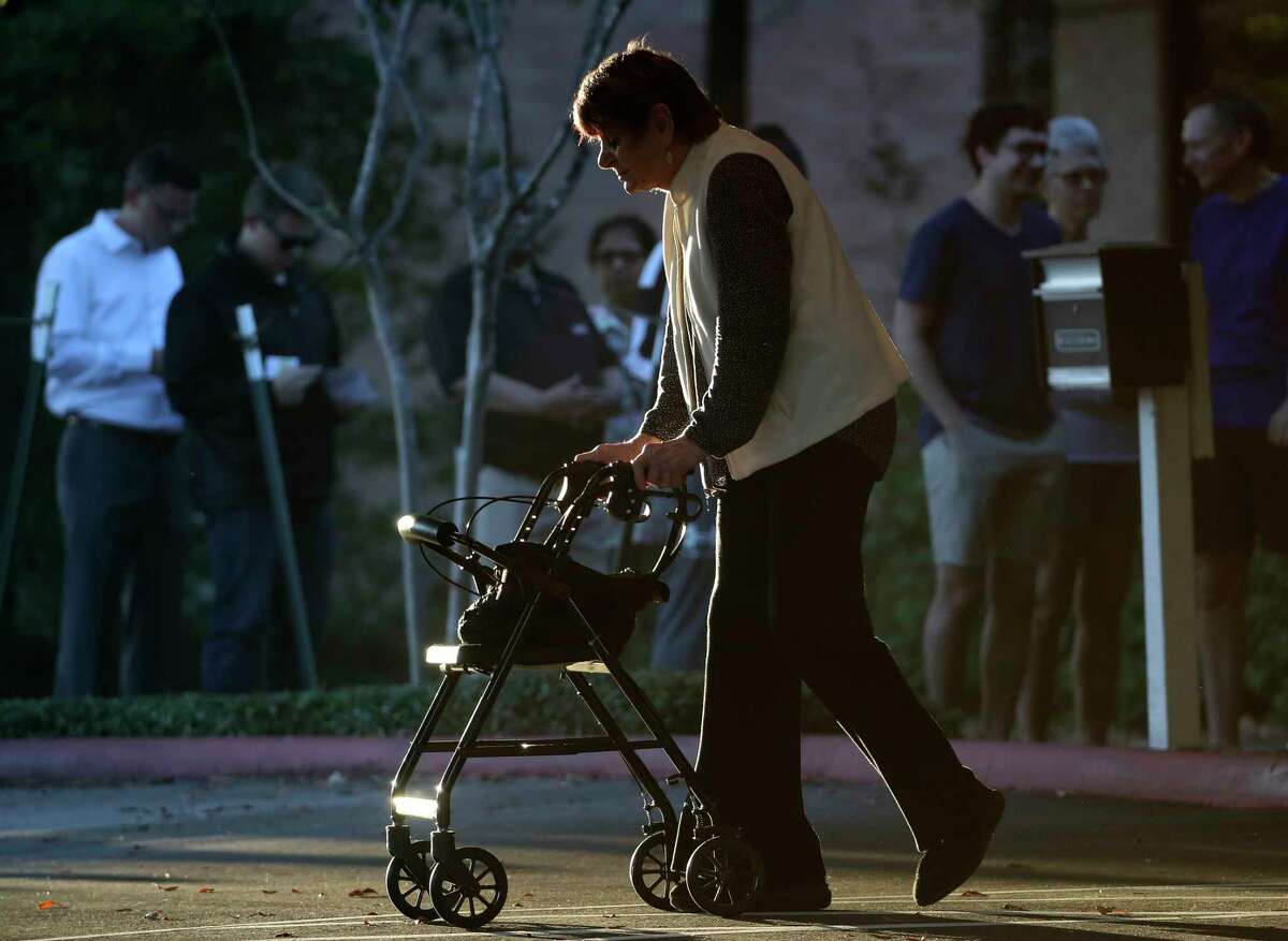 A woman walks to her vehicle with the help of a walker after voting on Election Day at the South Montgomery County Community Center, Tuesday, Nov. 8, 2022, in The Woodlands.
