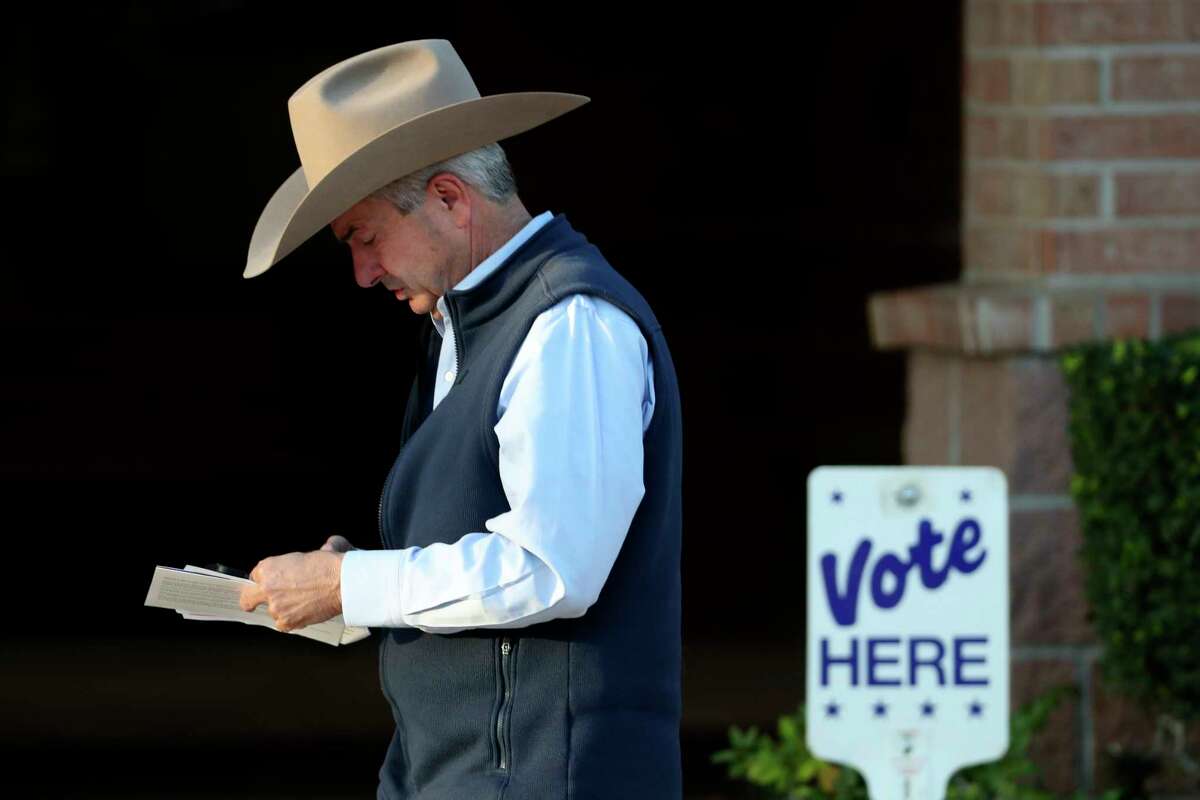 A man wears a cowboy hat has he heads to the back of the line to vote on Election Day at the South Montgomery County Community Center, Tuesday, Nov. 8, 2022, in The Woodlands.