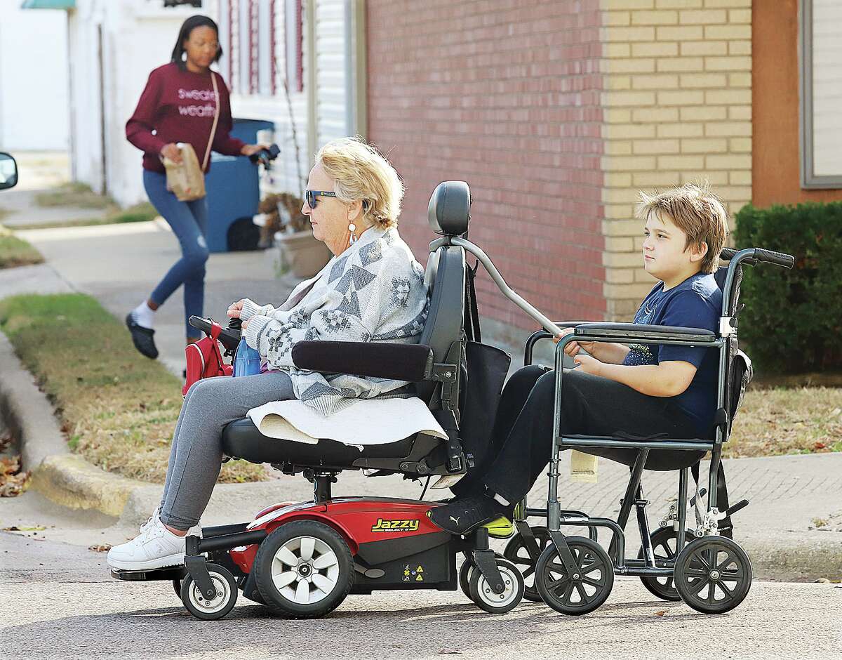 John Badman|The Telegraph Grandma was giving her grandson a ride Monday afternoon, but he had to hold on. Twylar Englar used her motorized scooter to pull her grandson, Raylan Stufflebean, 9, down Lorena Avenue in Wood River as he sat in her wheelchair behind her and hung on. The two were headed for Raylan's house not far away and enjoying the pleasant fall weather.