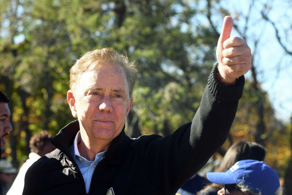Gov. Ned Lamont gestures to a supporter during a visit to Winthrop School on Election Day, in Bridgeport, Conn. Nov. 8, 2022.