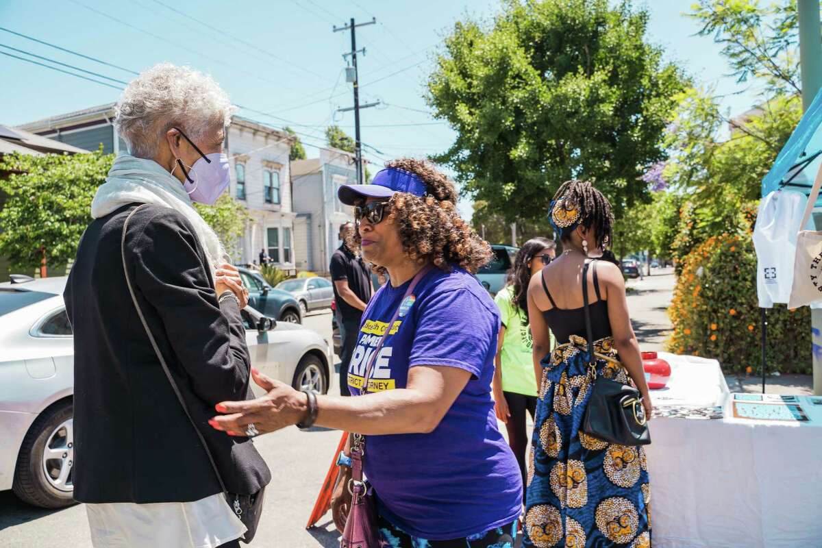 Erika Huggins (left) and Candidate for Alameda County District Attorney, Pamela Price (right), stop for a chat at the Free The People Block Party in West Oakland, Calif to celebrate Juneteenth.