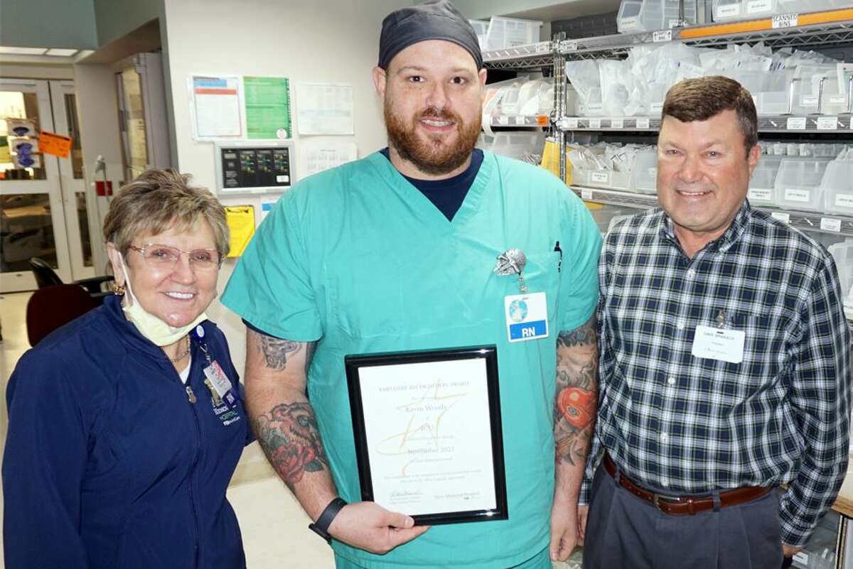 Kevin Woods, center, of ICU is Alton Memorial Hospital’s November Employee of the Month. He received the award Nov. 8 from Annette McCauley, manager of ICU, and AMH President Dave Braasch.  