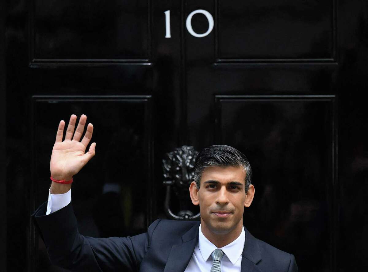 Britain's newly appointed Prime Minister Rishi Sunak waves as he poses outside to door to 10 Downing Street in central London, on October 25, 2022, after delivering his first speech as prime minister.