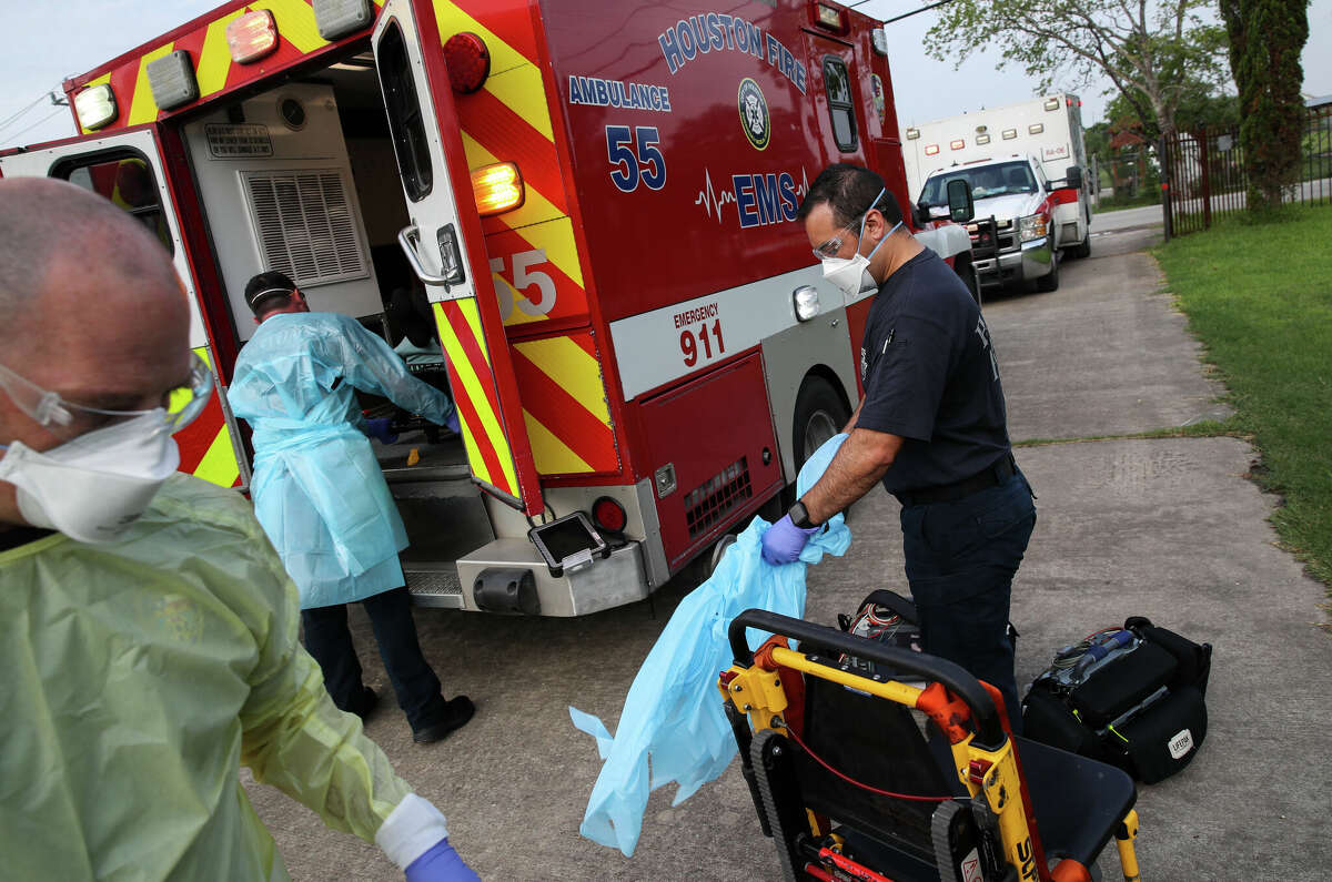 Houston firefighters remove PPE after a call for a man experiencing symptoms of COVID-19 on Thursday, Aug. 5, 2021, at a home in Houston.