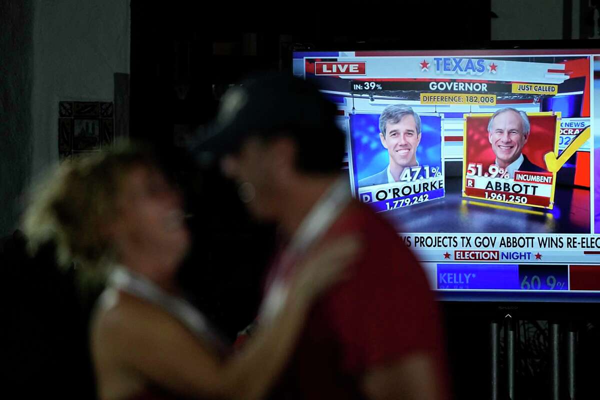A couple celebrates as results for Texas Gov. Greg Abbott are displayed on a television during an election night party Tuesday, Nov. 8, 2022, in McAllen, Texas. (AP Photo/David J. Phillip)