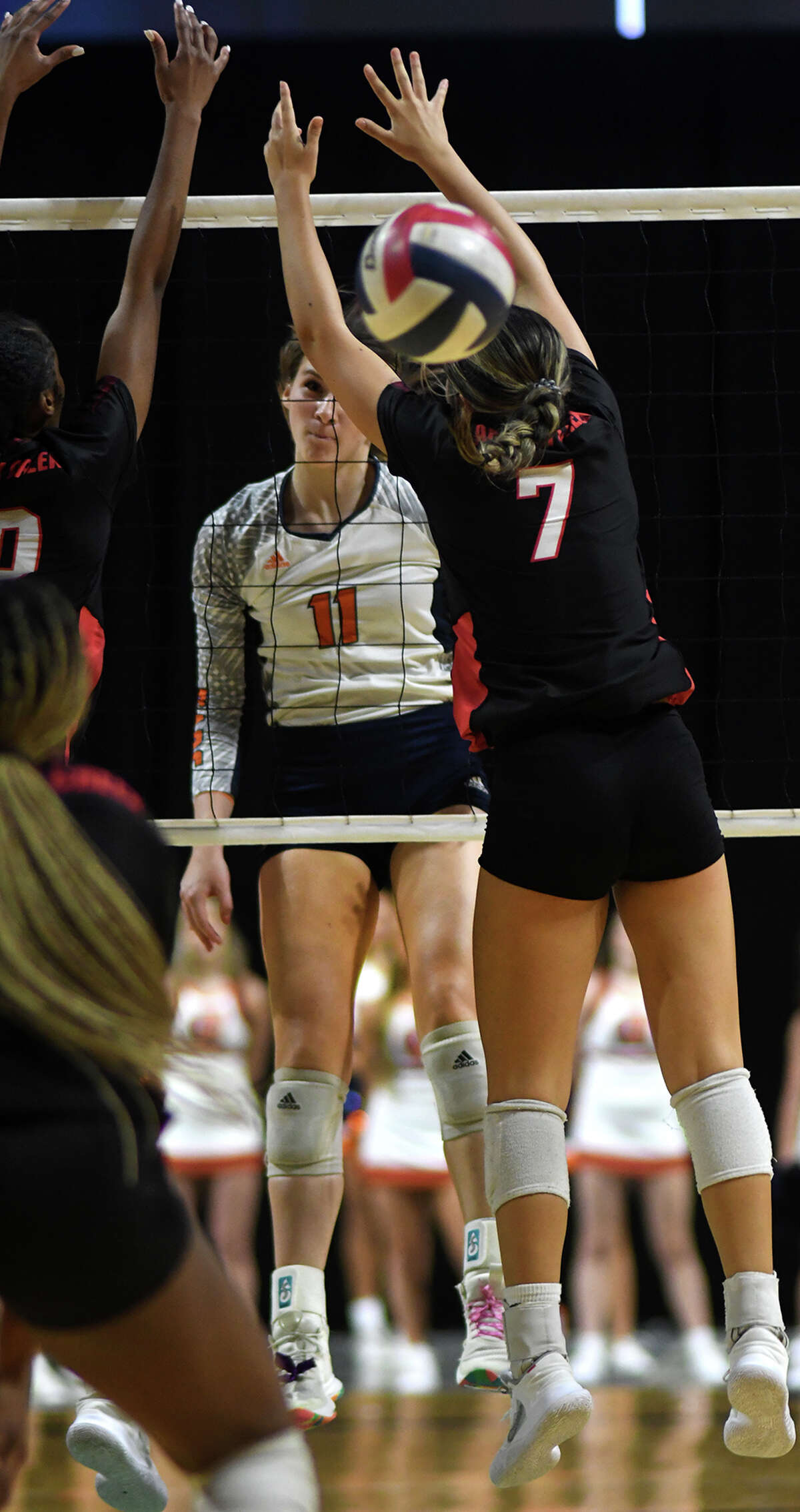 Bridgeland senior middle blocker Molly McClure (11) gets a kill past Langham Creek senior right side Jacqueline Salazar (7) during the third set of their Region II-6A Quarterfinal Playoff matchup at The Berry Center in Cypress on Nov. 8, 2022.