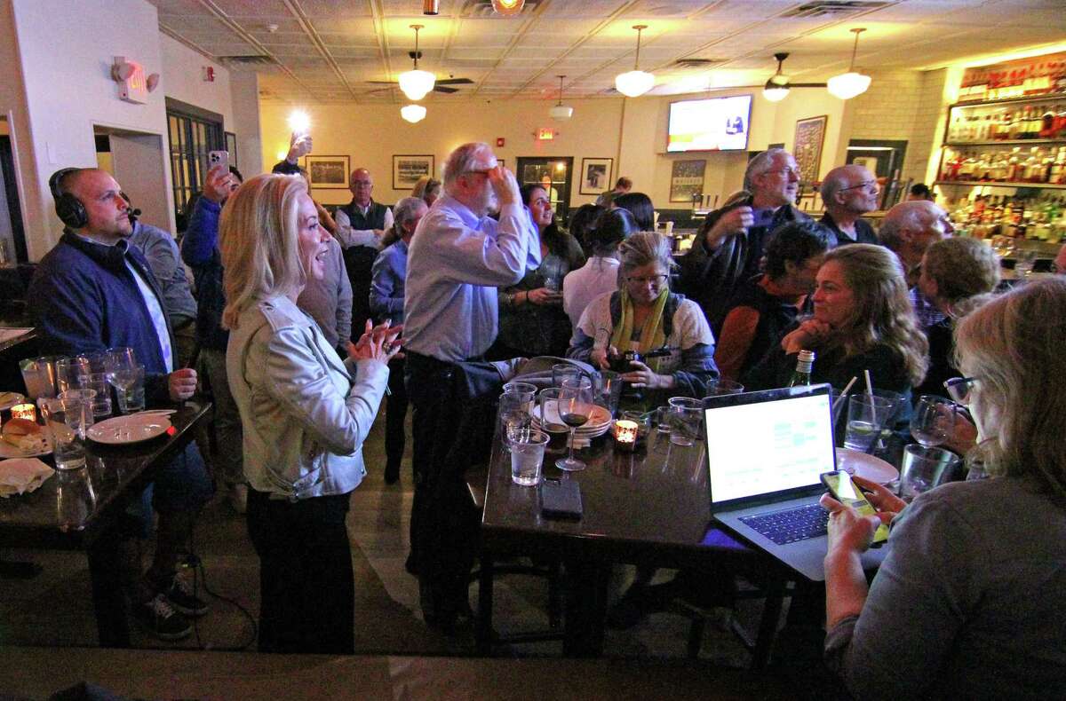 Trevor Crow, the Democratic candidate for state senate, at left, watches returns at the Old Greenwich Social Club after the polls have closed in the midterm election in Old Greenwich, Conn., on Tuesday November 8, 2022. Excitement ensued after the election returns became so close that an automatic recount would happen, putting the long held Republican seat in jeopardy.