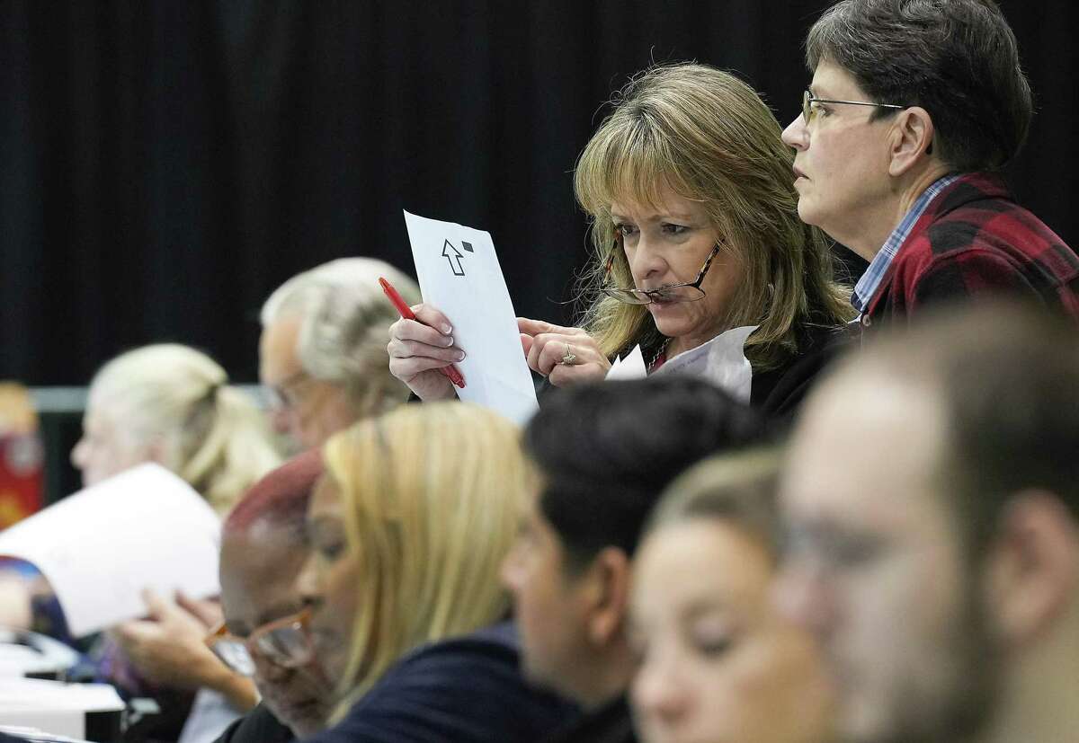 Harris County Elections officials look over ballots in the central count area at NRG Arena on Tuesday, Nov. 8, 2022 in Houston.