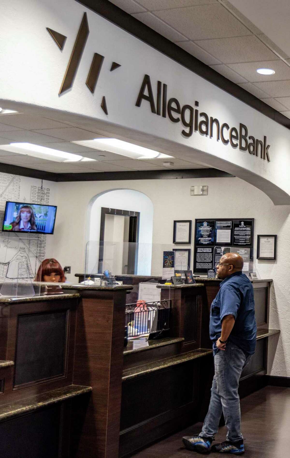 Bank teller Michaelin Gonzales helps a client with a transaction on September 30, 2022 at the Allegiance Bank East End in Houston. Allegiance Bank, was ranked No.3 among large top companies to be employed.