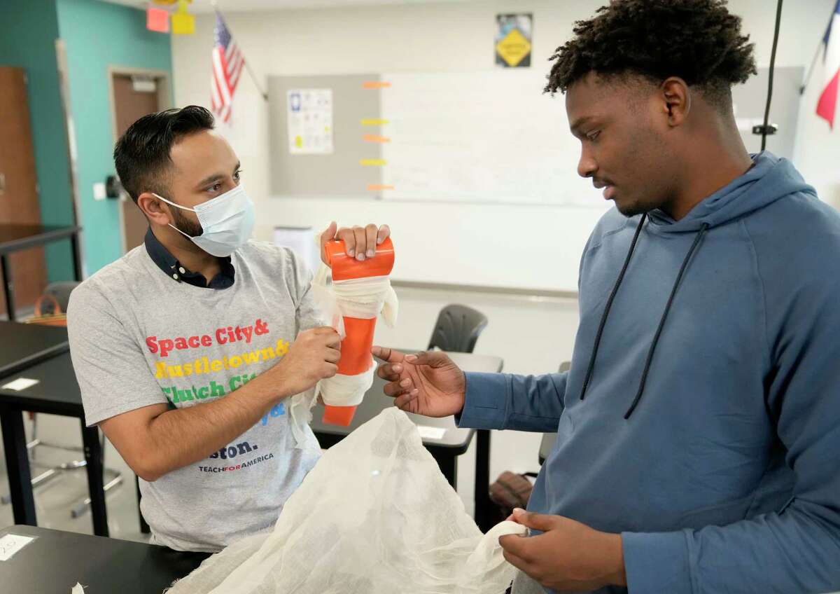 Nabeel Ahmad, a aesculapian  pupil  from the University of Houston College of Medicine, left, has Damion Lewis, a senior, right, use  a splint to his limb  Wednesday, Nov. 9, 2022, successful  Houston. In the Healthcare Collaborative, aesculapian  students service  arsenic  mentors to students who are funny   successful  pursuing a vocation  successful  wellness  sciences.