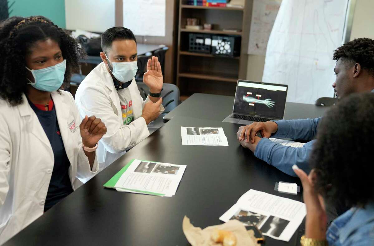 Sylvia Omozee, near  and Nabeel Ahmad, 2nd  from left, some  aesculapian  students from the University of Houston College of Medicine, enactment    with Yates High School seniors, Briana Webber and Damion Lewis, right, Wednesday, Nov. 9, 2022, successful  Houston. In the Healthcare Collaborative, aesculapian  students service  arsenic  mentors to students who are funny   successful  pursuing a vocation  successful  wellness  sciences.