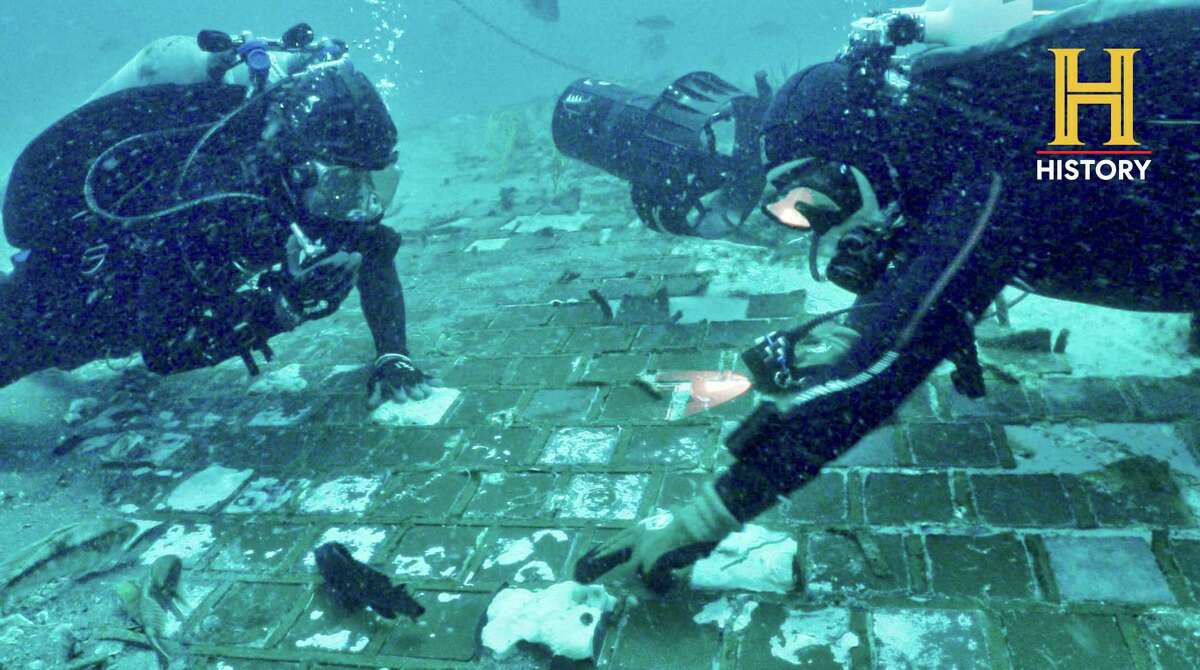 In this photo provided by the History Channel, underwater explorer and marine biologist Mike Barnette and wreck diver Jimmy Gadomski explore a 20-foot segment of the 1986 Space Shuttle Challenger that the team discovered in the waters off the coast of Florida during the filming of the new series, “The Bermuda Triangle: Into Cursed Waters,” premiering Tuesday, Nov. 22. 