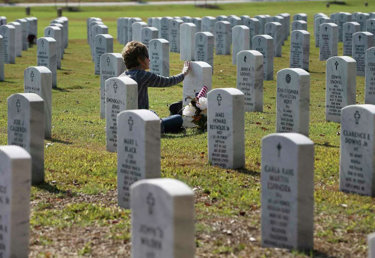 A woman visits her husband’s grave at Fort Sam Houston National Cemetery in 2020. We owe veterans a debt we can never repay.