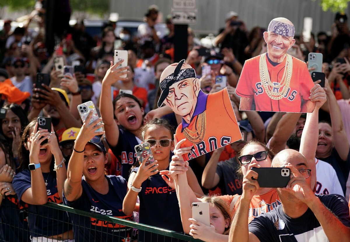 Fans with Mattress Mack drawings watch the float with the trophy pass by during the Houston Astros World Series parade downtown on Monday, Nov. 7, 2022 in Houston.