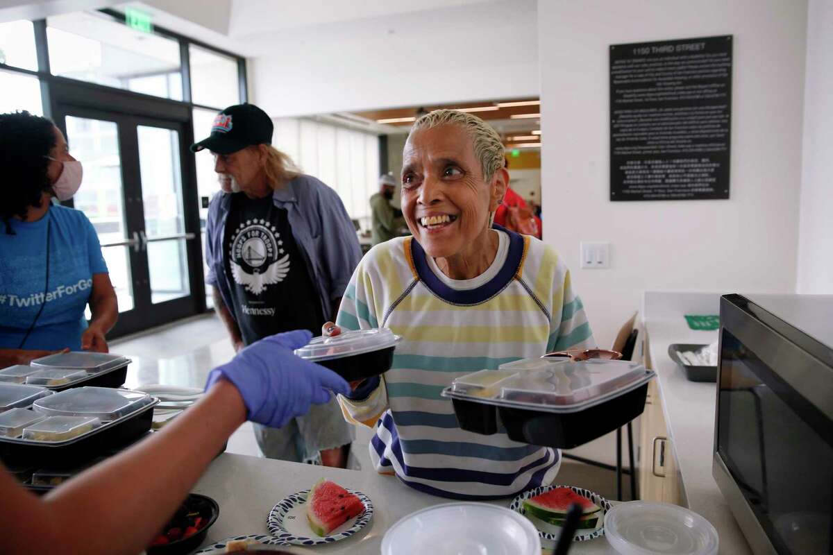 Margie Talavera, Edwin M. Lee Apartmets resident, picks up a meal in the Community Room as Twitter for Good host a lunch with Twitter volunteers for veterans at the Edwin M. Lee Apartmets on Monday, September 12, 2022 in San Francisco, Calif.
