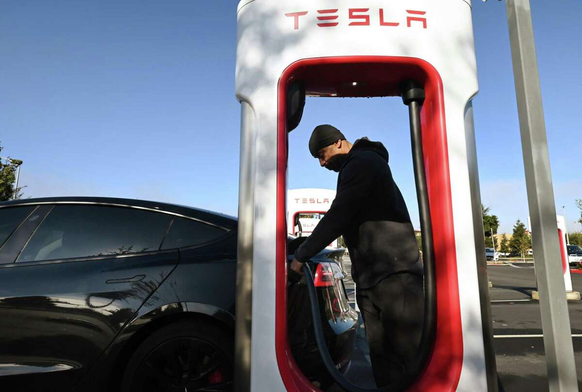 Mike Evans charges his Tesla at a Petaluma station. Like many Californians, he has a complex view of Elon Musk, the head of Tesla and now Twitter.