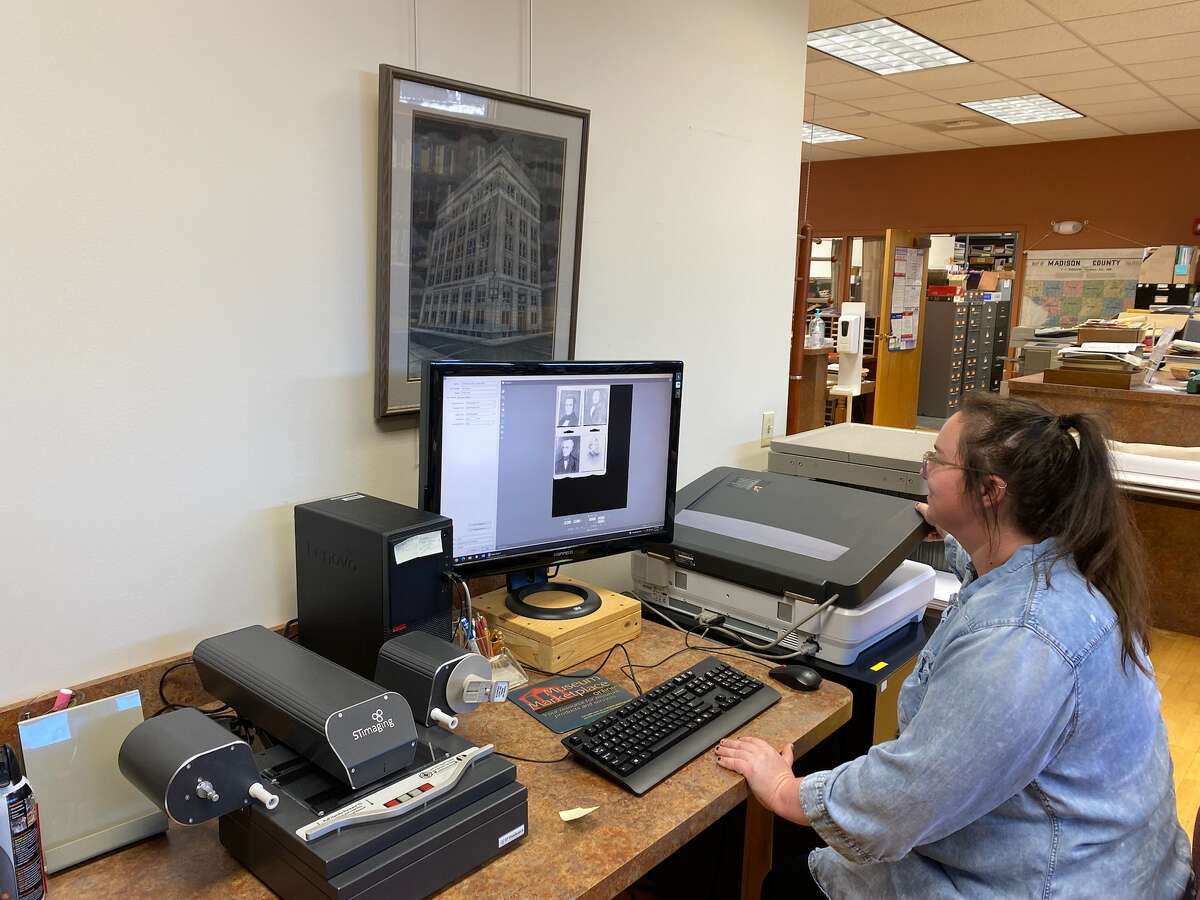 Madison County Historical Society student intern Reahn Richards uses one of the organization’s two flatbed scanners to scan images.