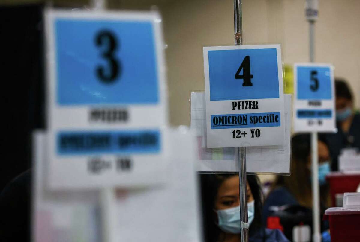 Signs for the Pfizer Omicron booster shots are displayed outside of tables where the vaccines are administered at the Santa Clara County Fairgrounds on Wednesday, September 7, 2022, in San Jose, Calif. Folks ages 12 and up were able to receive their second Omicron booster shot at the Covid-19 vaccination clinic.