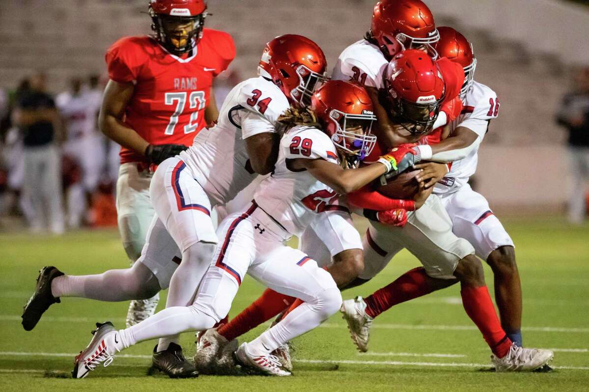 Manvel defenders Frederick Kalu (34), Caleb Riggs (29), and Darrell Gordon (31) tackle Waltrip quarterback Shaun Crawford (1) after a short run in a Region III-5A Division I bi-district high school football game between Waltrip and Manvel Thursday, Nov 10, 2022, in Houston.