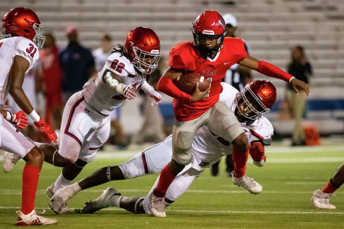 Waltrip quarterback Shaun Crawford (1) spins away from Manvel defensive lineman Jalen Charles (92) in a Region III-5A Division I bi-district high school football game between Waltrip and Manvel Thursday, Nov 10, 2022, in Houston.