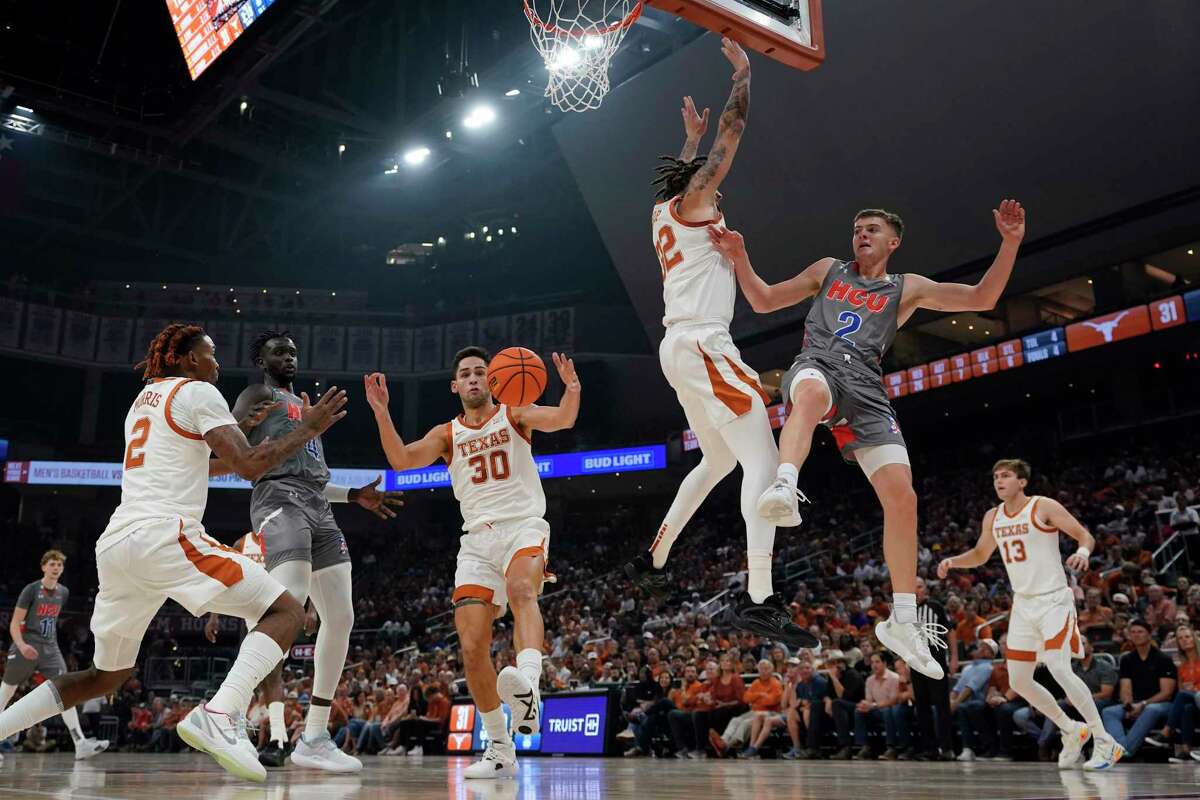 Houston Christian guard Pierce Bazil (2) loses control of the ball as he drives to the basket against Texas forward Christian Bishop (32) during the first half of an NCAA college basketball game, Thursday, Nov. 10, 2022, in Austin, Texas. (AP Photo/Eric Gay)