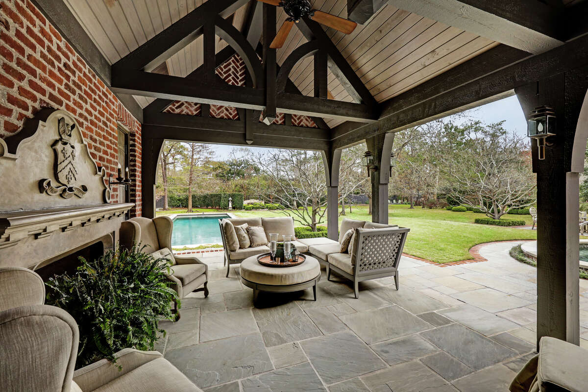 A second outdoor living space has a fireplace and view of the pool.