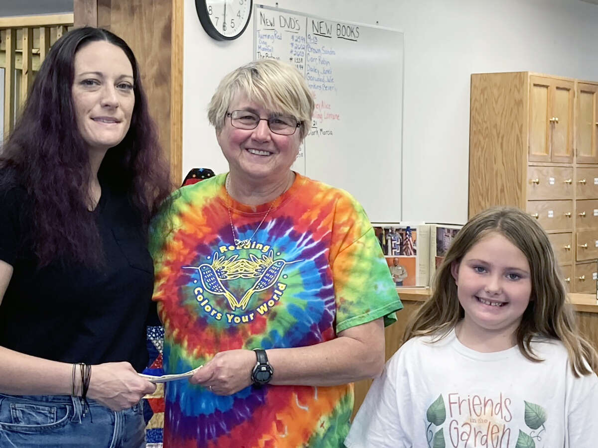 Members of the Newman family recently made a donation to M-C River Valley Public Library in Meredosia in memory of Alex Newman, who died in 2008. Newman's sister, Kristi Smith (left) and Isabella Adams (right) made the presentation to librarian Janet Wells.