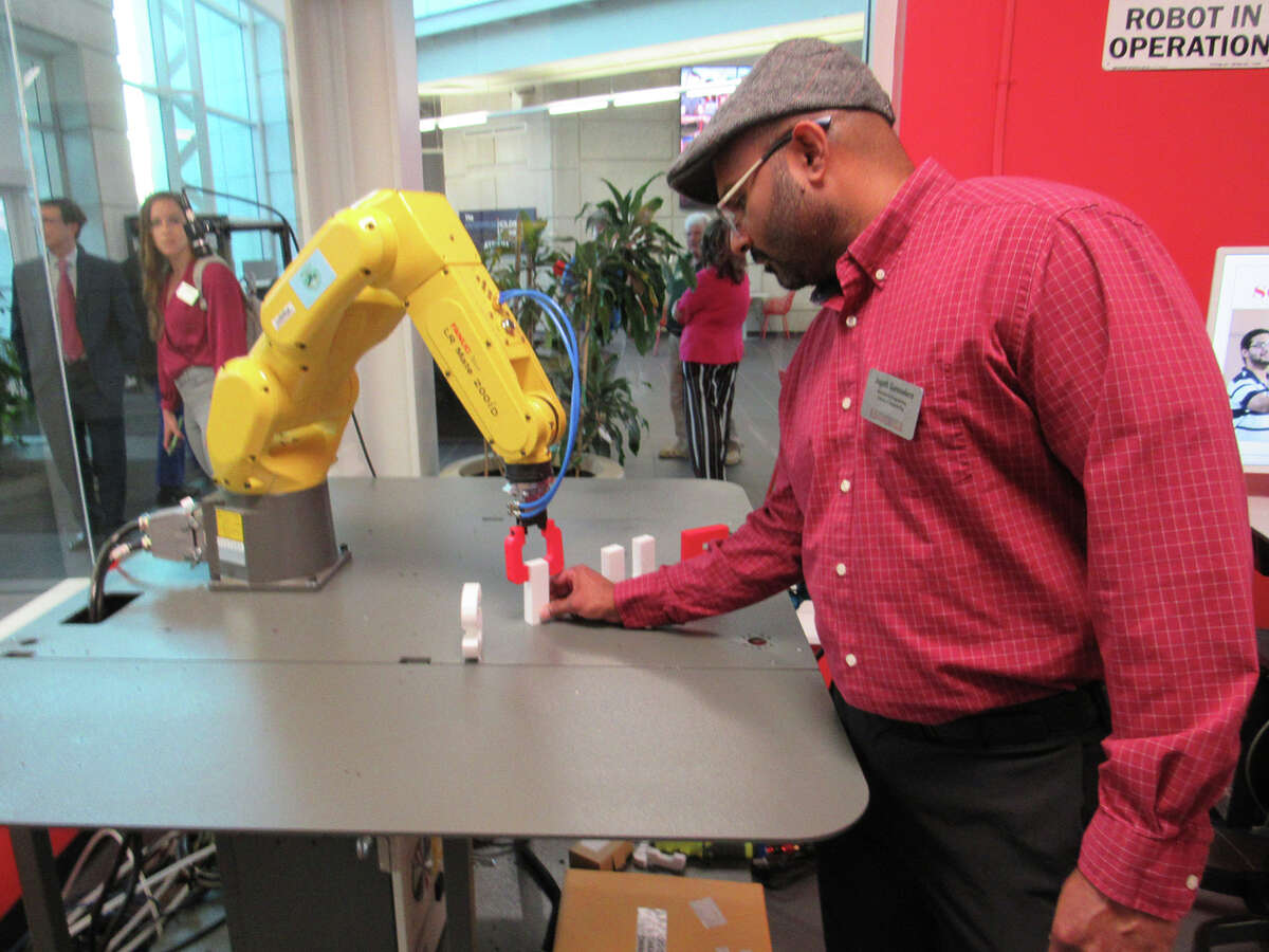 Dr. Jagath Gunsasekera, lab manager and an instructor in the Mechanical and Industrial engineering department, works with a robot Thursday night at SIUE during the unveiling of the Enterprise Holdings Foundation Atrium and robotics lab at the School of Engineering.