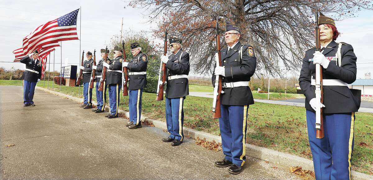 John Badman|The Telegraph Members of the Alton VFW Post 1308 present arms in respect Friday as taps is played nearby by former Alton High School band director David Drillinger to end the posts annual Veterans Day Ceremony.