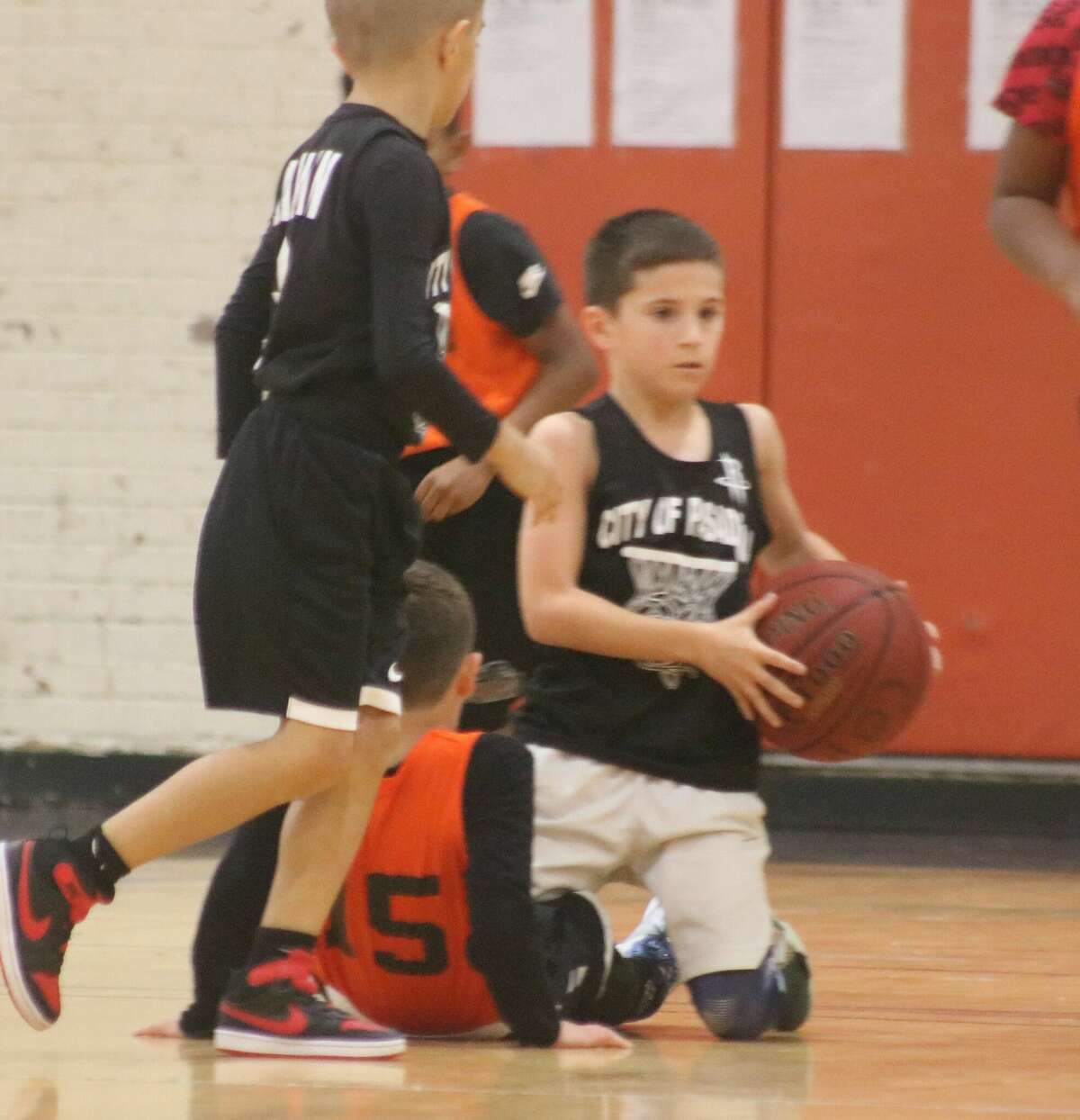   One of the Slattery boys comes up with a loose ball during a Pasadena youth basketball game last winter at PAL Gym.