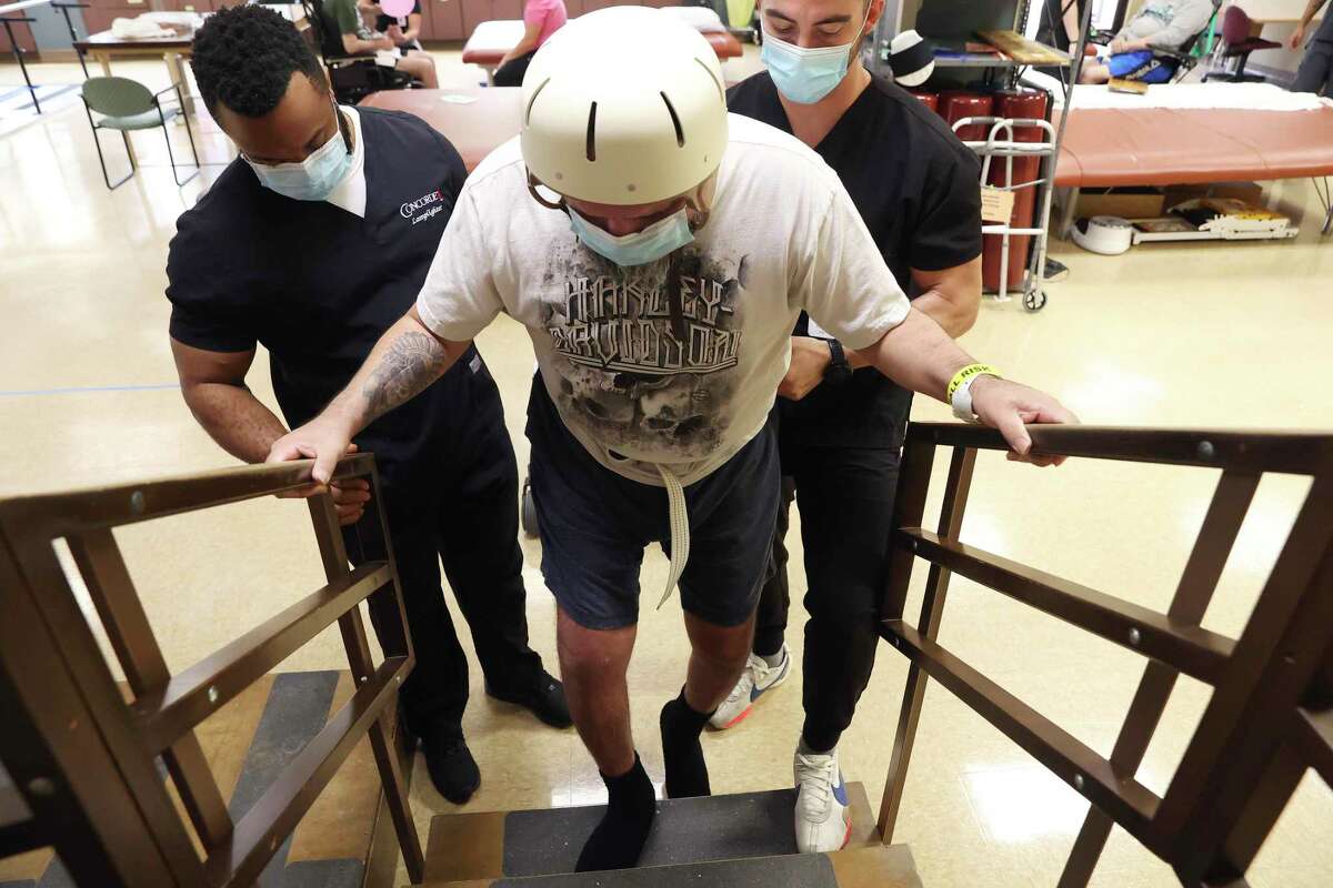 Joe Angel Garcia, 43, struggles to climb a set of steps at Warm Springs Rehabilitation Hospital. Garcia suffered severe brain, spinal and other injuries after a drunken driver drove a three-ton Lincoln Navigator into his motorcycle on Sept. 19, 2021. “He’s not the same Joe and never will be,” said his wife, Elizabeth Guajardo.