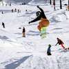 2022年11月11日，在加州特拉基的北风度假村，一名滑雪者在滑雪季的开幕日跳过一座小山。