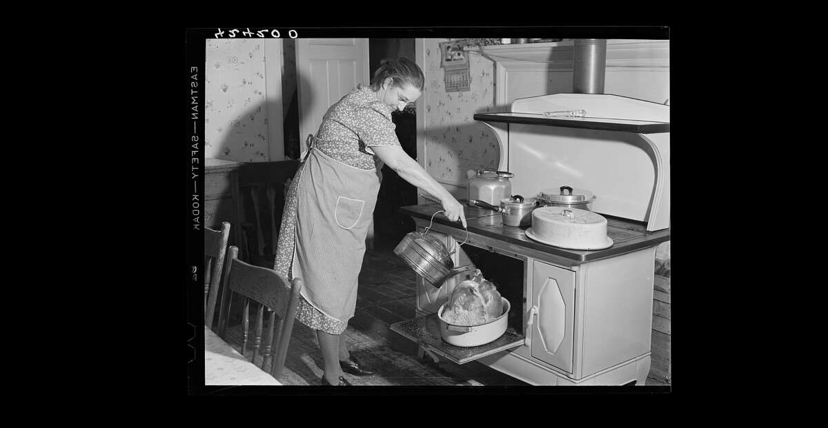 Mrs. T. M. Crouch, of Ledyard. Connecticut pouring some water over her twenty-pound turkey on Thanksgiving Day