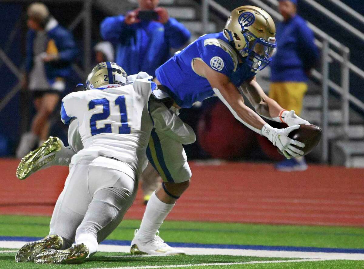 Alamo Heights receiver Rett Andersen reaches for the end zone to score against Kerrville Tivy’s Adan Hernandez (21) during high school football playoffs action at Alamo Heights on Friday, Nov. 11, 2022.