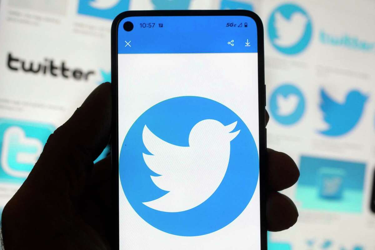 FILE - The Twitter logo is seen on a cell phone, Friday, Oct. 14, 2022, in Boston. The “official” designation for major corporate accounts on Twitter appeared, vanished, and depending on the account, appeared or vanished again and some companies took to the social media platform to warn of imposters.