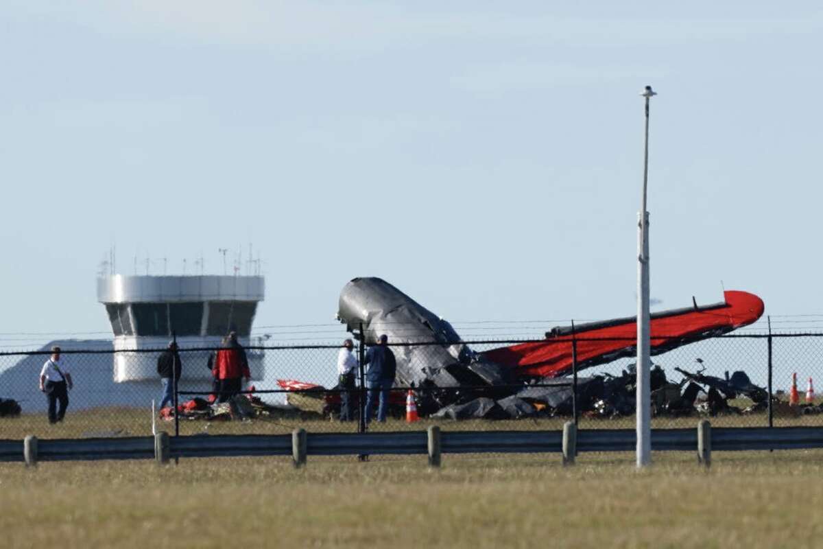 Damage from a mid-air collision between two planes sits within the fence line of the Dallas Executive Airport on Saturday, Nov. 12, 2022.