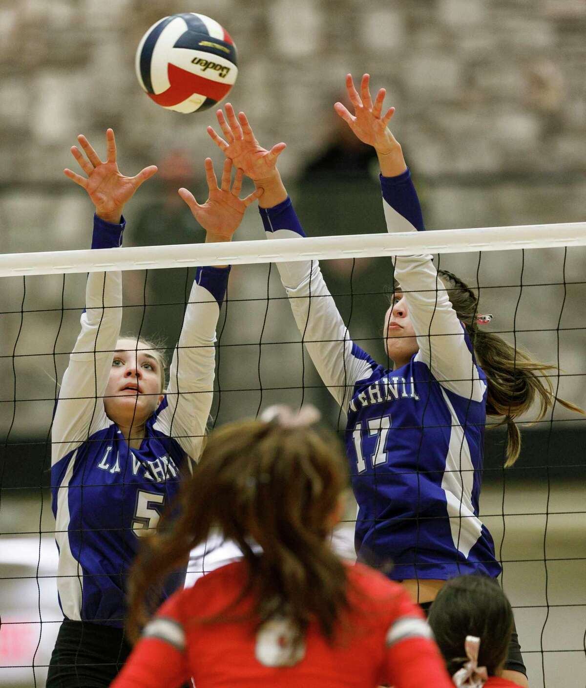 La Vernia's Mikayla Lindsey (5) and Madison Whatley (17) attempt a block against the Bellville Brahmas in the second set of the Region IV-4A volleyball championship at Littleton Gym in San Antonio, Texas, Saturday, Nov. 12, 2022. Belleville secured its third straight Region IV-4A volleyball championship with a 21-25, 26-24, 25-14, 21-25, 15-11 victory against La Vernia.