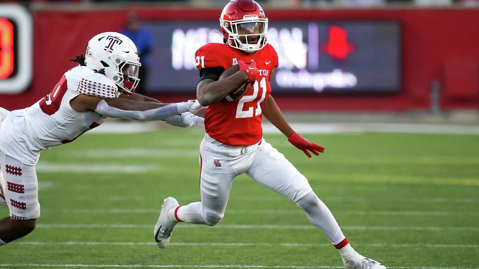 HOUSTON, TX NOV 12: Houston Cougars running back Stacy Sneed (21) evades a tackle by Temple Owls cornerback Cameron Ruiz (19) during the college football game between the Temple Owls and Houston Cougars at TDECU Stadium in Houston, Texas.