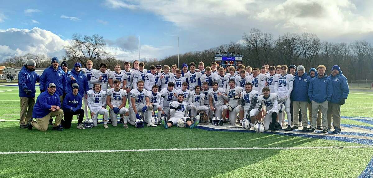 Gladwin's football team poses with the championship trophy after beating Muskegon Oakridge 26-8 in a Division 5 regional final on Saturday, Nov. 12, 2022.