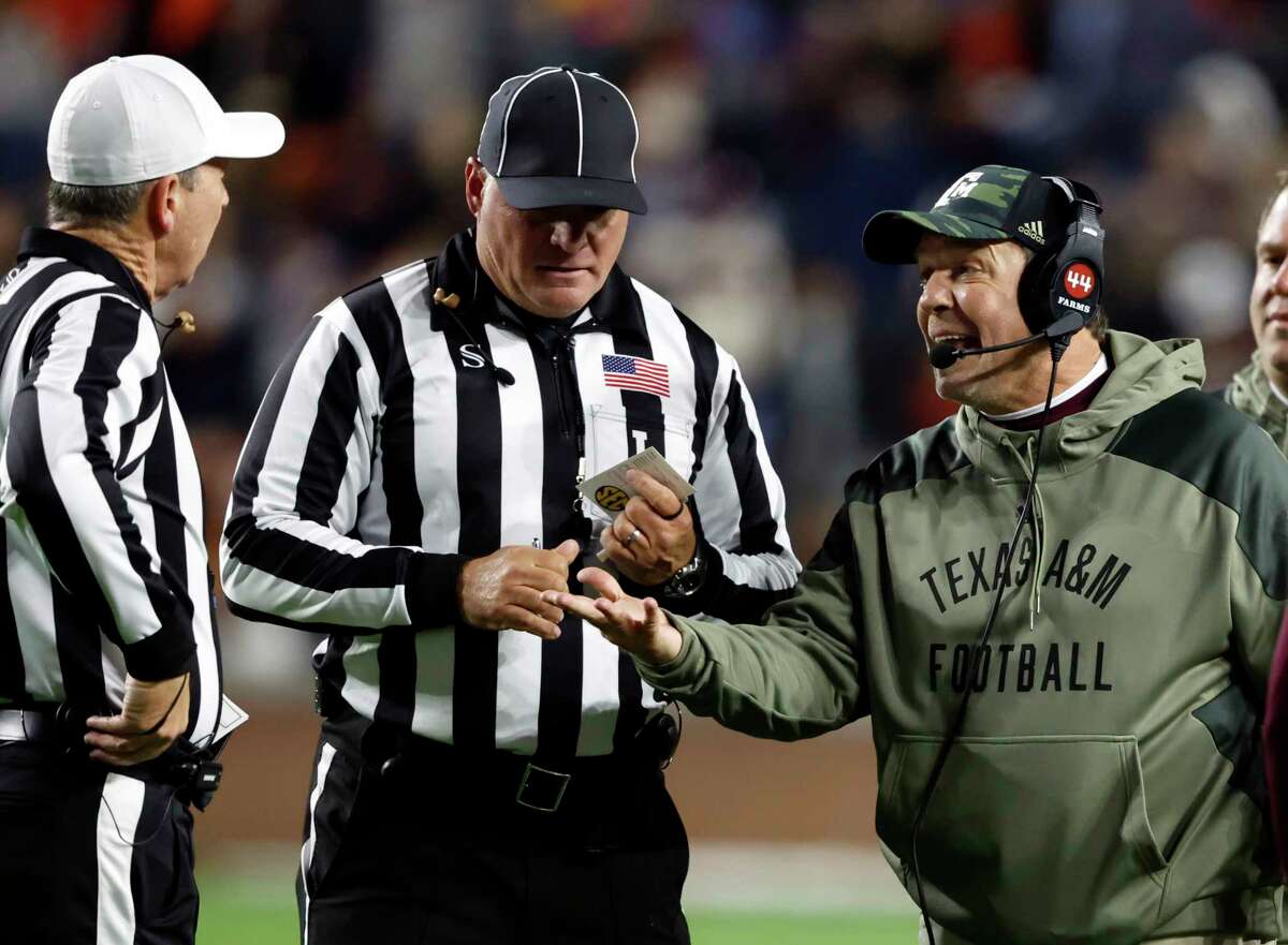 Texas A&M head coach Jimbo Fisher talks with referee David Smith during the first half of an NCAA college football game against Auburn, Saturday, Nov. 12, 2022, in Auburn, Ala. (AP Photo/Butch Dill)