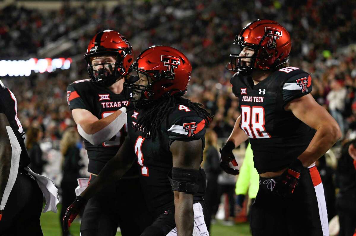 Texas Tech running back SaRodorick Thompson (4) reacts to a touchdown with wide receiver Coy Eakin, left, and tight end Baylor Cupp (88) against Kansas during the first half of an NCAA college football game, Saturday, Nov. 12, 2022, in Lubbock, Texas.