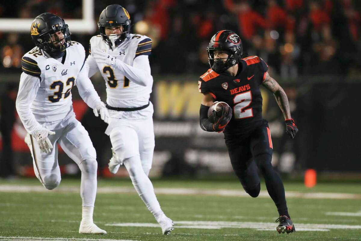 Oregon State wide receiver Anthony Gould (2) runs past California safety Daniel Scott (32) and wide receiver Kenden Robinson Jr. for a touchdown off of a punt return during the first half of an NCAA college football game on Saturday, Nov 12, 2022, in Corvallis, Ore. (AP Photo/Amanda Loman)