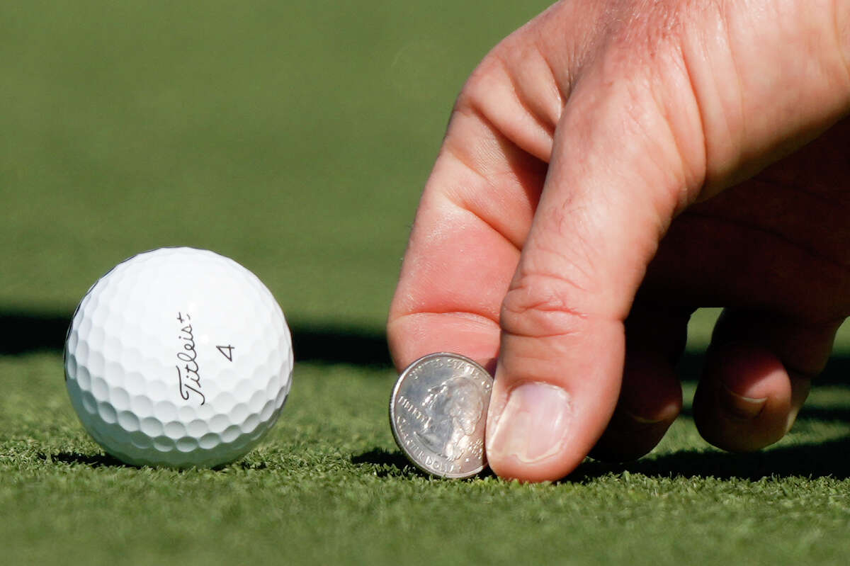 Justin Rose picks pop his ball marker on the sixth green during the final round of the Houston Open golf tournament, Sunday, Nov. 13, 2022, in Houston.